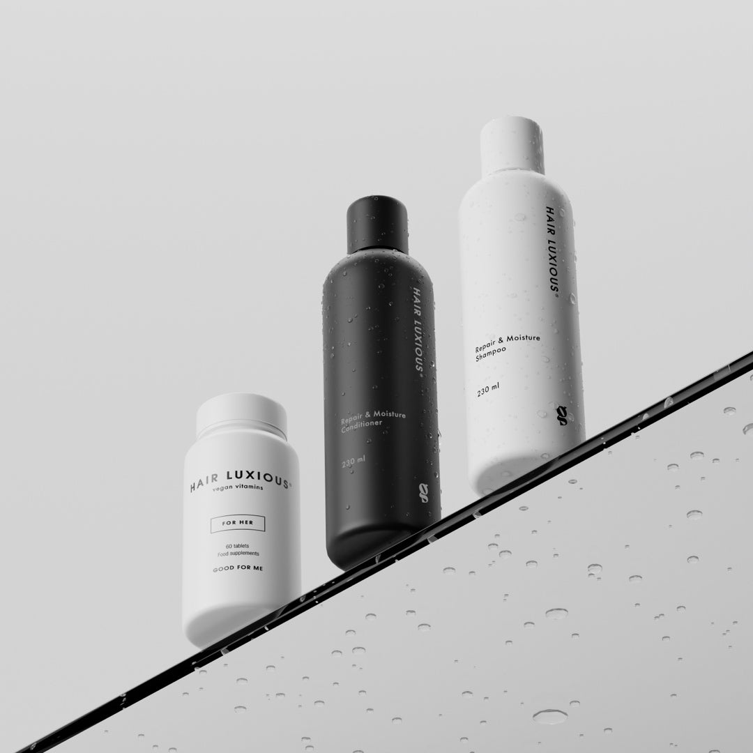 Hair Luxious Repair & Moisture shampoo and conditioner with a For Her supplement jar on a wet surface