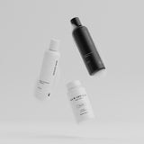 Hair Luxious Repair & Moisture shampoo, conditioner and For Her supplement jar floating against a grey background