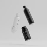 Hair Luxious Repair & Moisture shampoo, conditioner and the black For Him supplement jar floating against a grey background