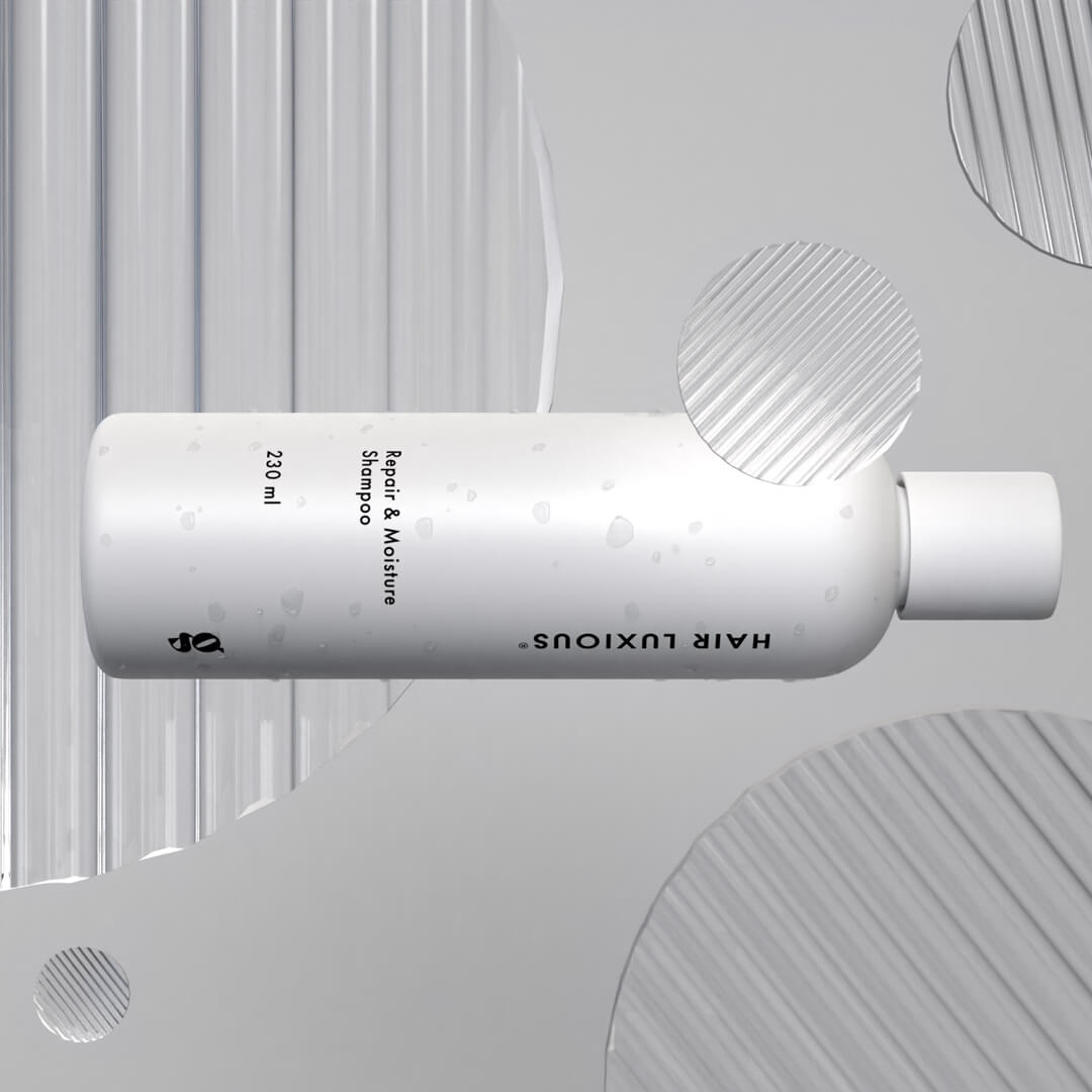 Hair Luxious Repair & Moisture Shampoo bottle lying on a grey background