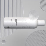 Hair Luxious Repair & Moisture Shampoo bottle lying on a grey background