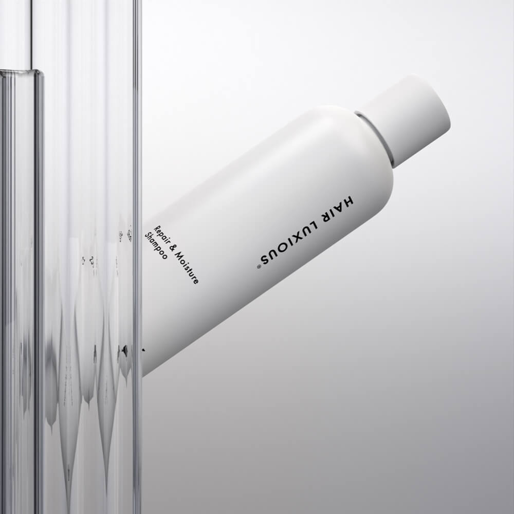 Hair Luxious Repair & Moisture Shampoo bottle against fluted glass