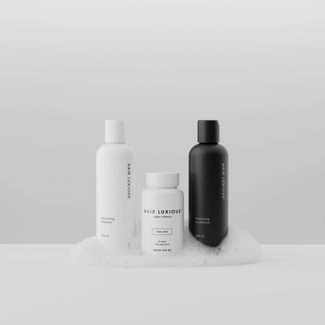 Hair Luxious Volumizing shampoo and conditioner with a For Her supplement jar resting on foam