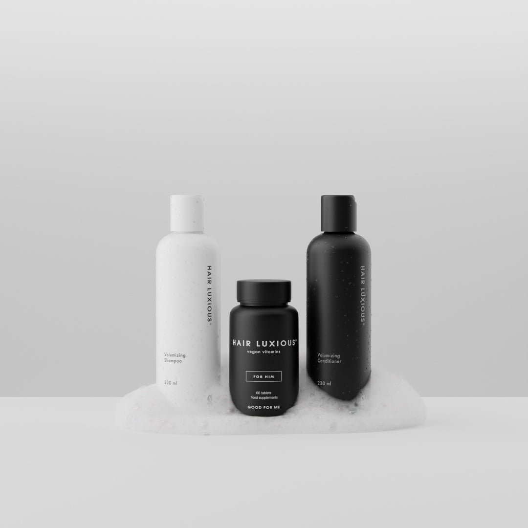 Hair Luxious Volumizing shampoo and conditioner with the black For Him supplement jar resting on foam