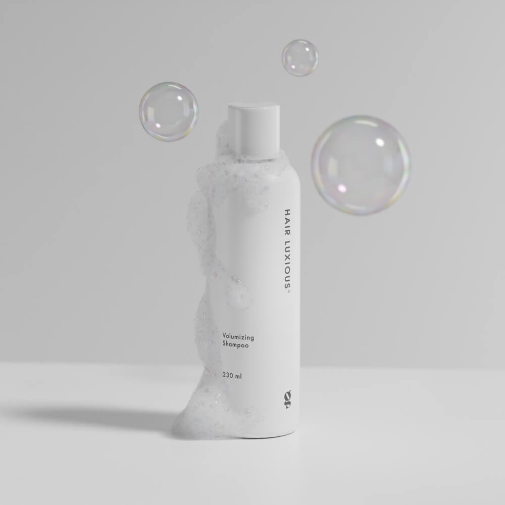 Hair Luxious Volumizing Shampoo bottle with soap bubbles