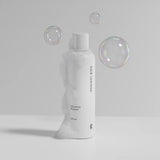 Hair Luxious Volumizing Shampoo bottle with soap bubbles