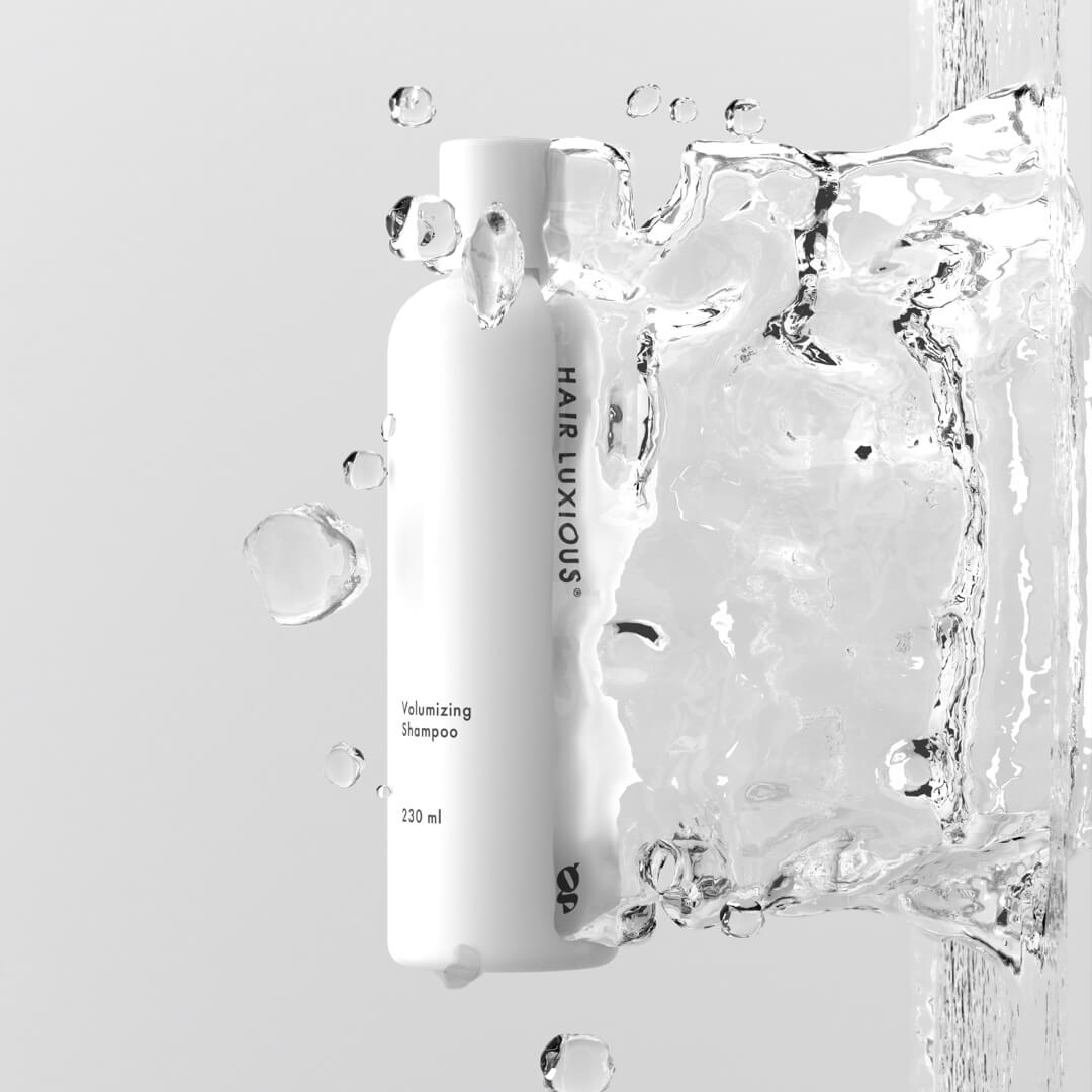 Hair Luxious Volumizing Shampoo bottle surrounded by splashing water