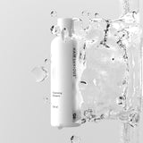 Hair Luxious Volumizing Shampoo bottle surrounded by splashing water